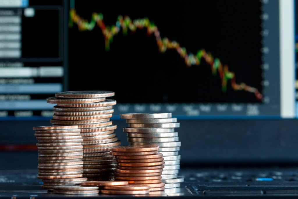 Stacks of coins  and a down trend chart as the background