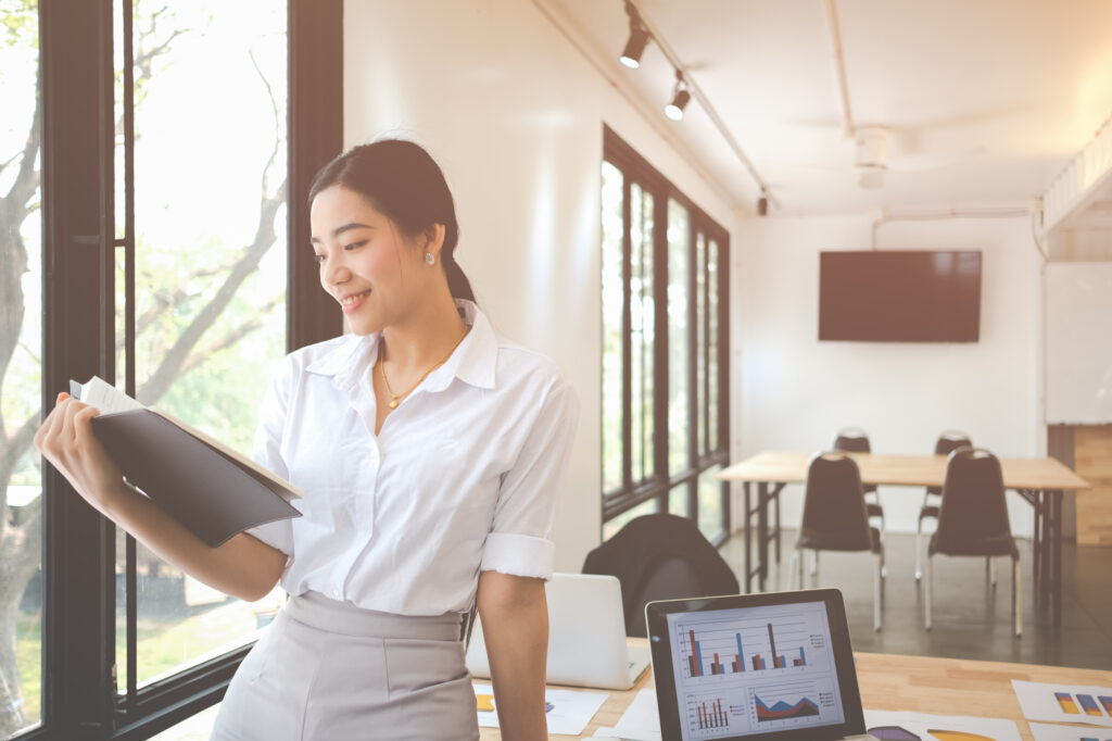 Portrait of smiling pretty young business woman on workplace, Calculating the cost of postage of a small package, Small business enterprise concerns for online Shopping
