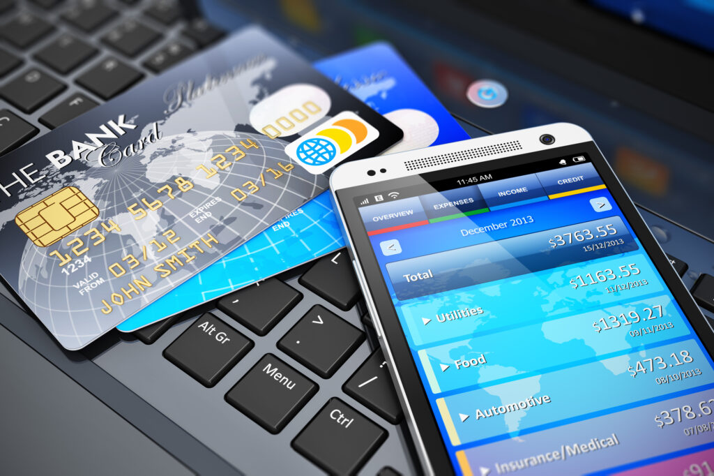 Mobile banking, financial success, accounting and electronic internet money payments business concept: macro view of stack of credit cards and modern touchscreen smartphone on office laptop keyboard with selective focus effect