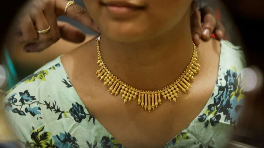 A woman tries on a gold necklace at a jewellery showroom during Dhanteras, a Hindu festival associated with Lakshmi, the goddess of wealth, in Mumbai, India, November 10, 2023. REUTERS/Francis Mascarenhas