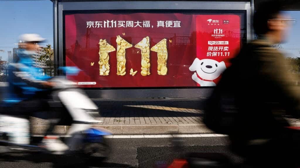People ride on a scooter past a JD.com's advertisement promoting Singles Day shopping festival, in Beijing, China October 26, 2023. REUTERS/Tingshu Wang