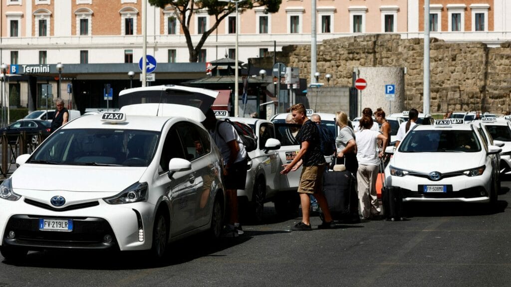 FILE PHOTO: People go on board of a taxi at Termini central station in Rome, Italy, July 17, 2023. REUTERS/Remo Casilli/File Photo