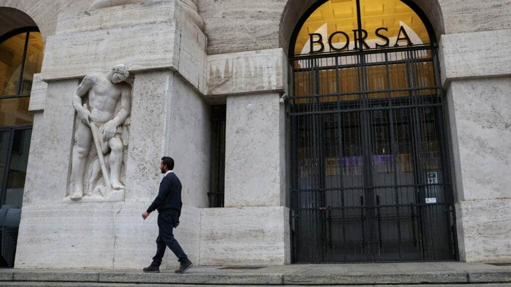 A man walks past the Milan stock exchange building, in Milan, Italy November 27, 2023. REUTERS/Claudia Greco