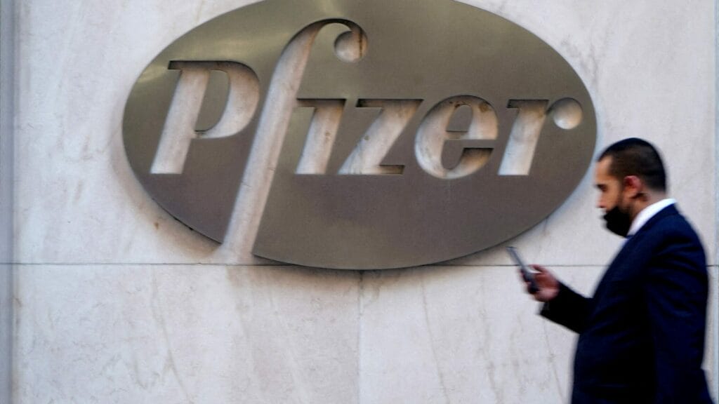FILE PHOTO: A person walks past the Pfizer Headquarters building in the Manhattan borough of New York City, New York, U.S., November 9, 2020. REUTERS/Carlo Allegri/File Photo