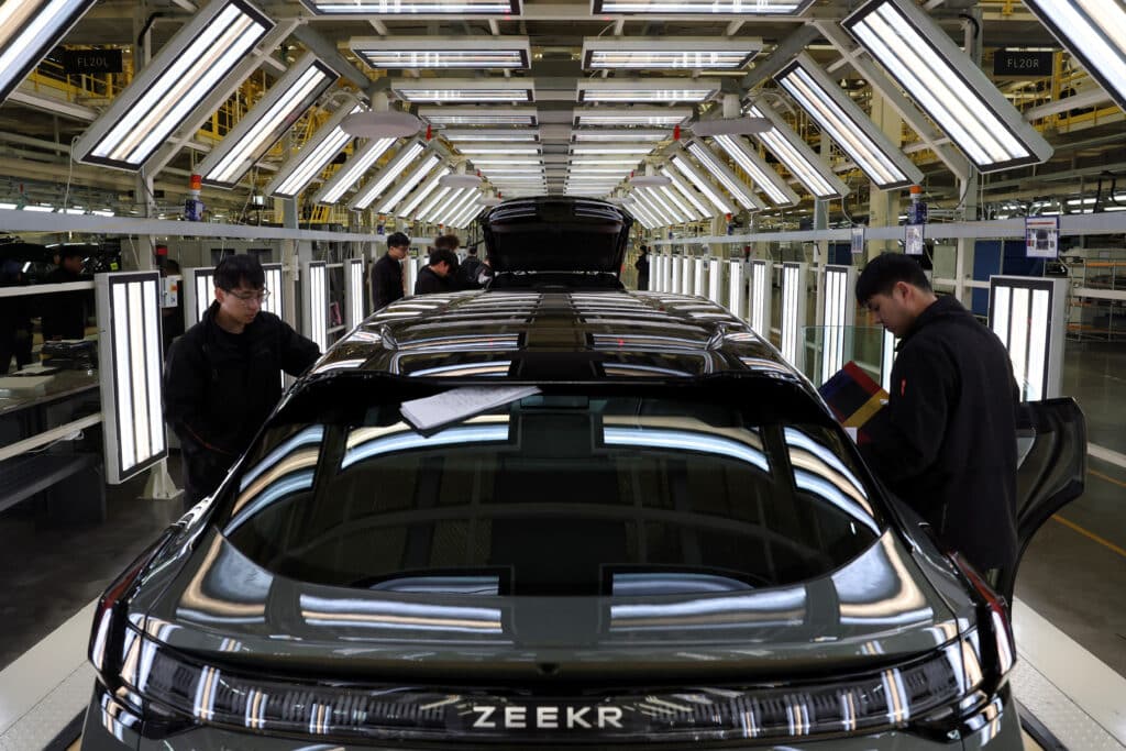 Employees work on the electric vehicle (EV) production line at the Zeekr factory in Cixi, Zhejiang province, China March 19, 2025. REUTERS/Florence Lo