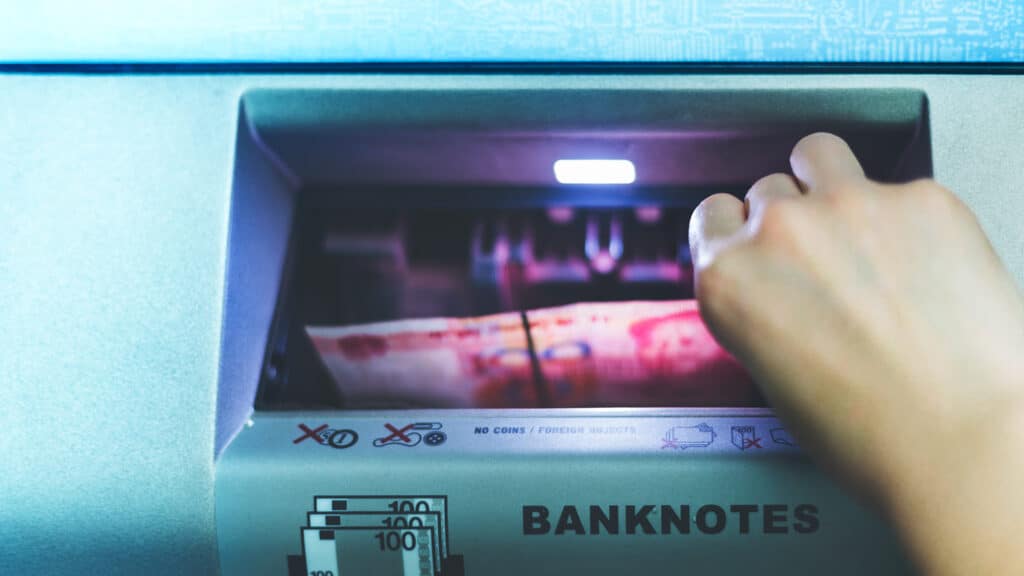 Woman using cash machine-ATM,close up view.
