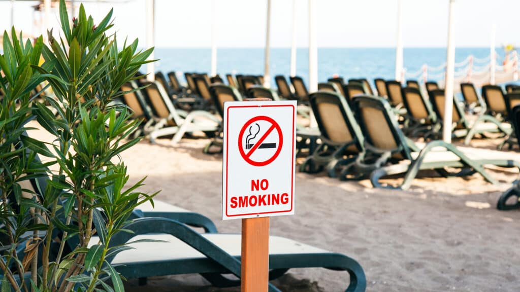 prohibition sign no smoking on sandy beach.