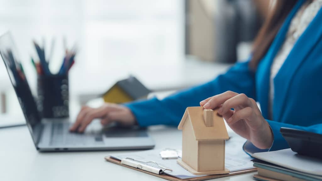 Real Estate Agent with Miniature House