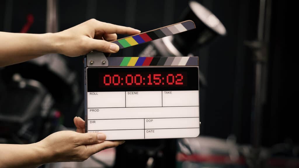 Digital film slate for filmmaker in set. Hand hitting timecode clapperboard or movie slate for Video Production. Digi number clapper board or film slates action on set. Tools in modern cinema industry