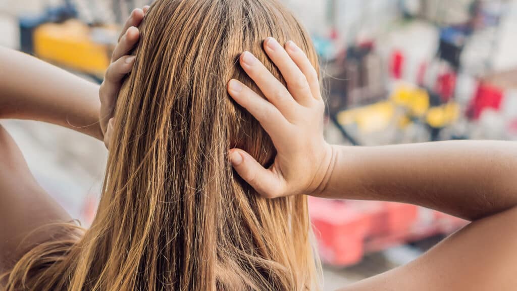 A young woman by the window annoyed by the building works outside. Noise concept. BANNER long format
