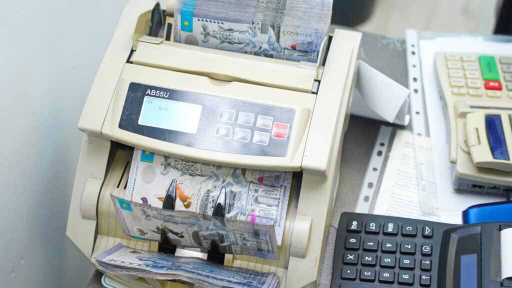 Almaty, Kazakhstan - 01.24.2025 : The banknotes of Kazakhstani tenge are recalculated in the counting machine.