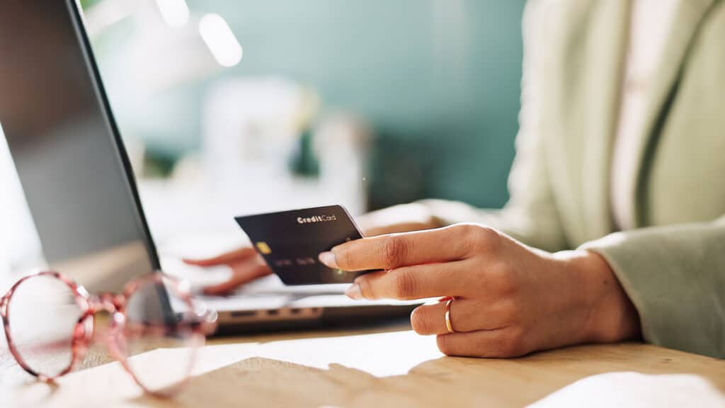 Credit card, hands and laptop with woman in office for company purchase, SaaS subscription or digital payment. Online banking, fintech and business budget with closeup of person for debit transaction