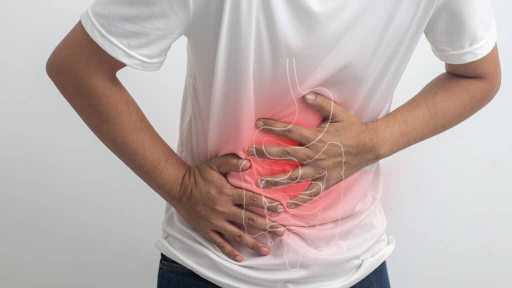 man having abdominal pain on white background