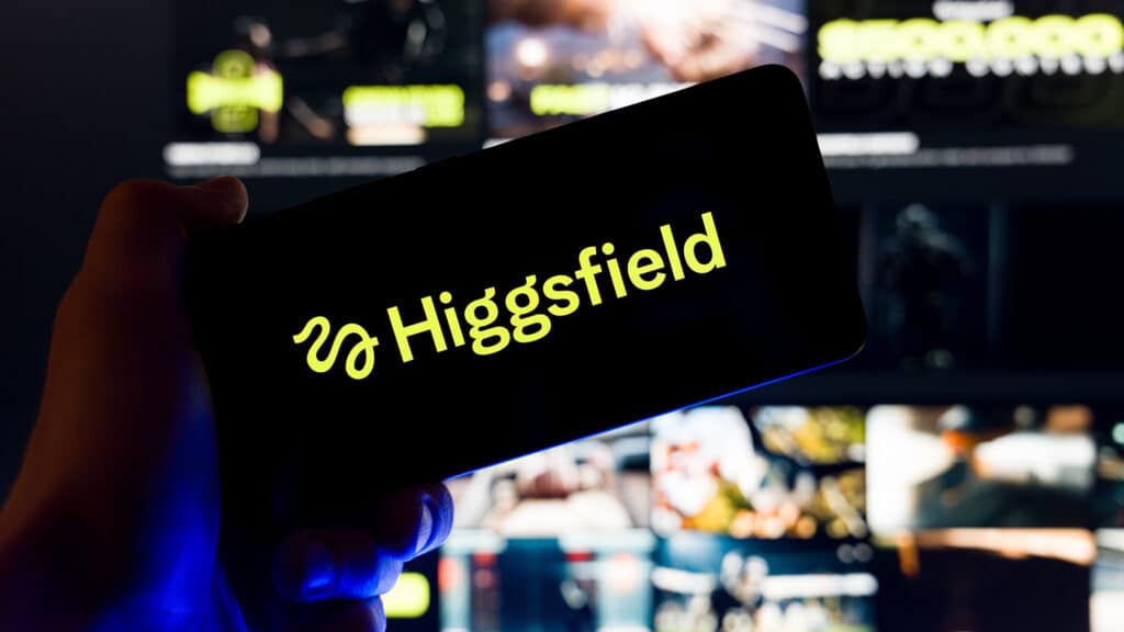 Hand holding smartphone displaying Higgsfield AI logo on screen with blurred website background, generative artificial intelligence video creation and social media content concept. Kaunas, Lithuania - 2026 February 19