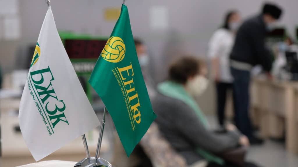 Almaty, Kazakhstan - 12.03.2020 : Flags with the inscription-abbreviation of the unified pension Fund of Kazakhstan are on the table in the building.