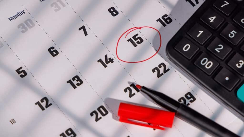 Modern office desk with a tax reminder on a calendar. Perfect for illustrating IRS filing, business accounting and personal budget planning today.