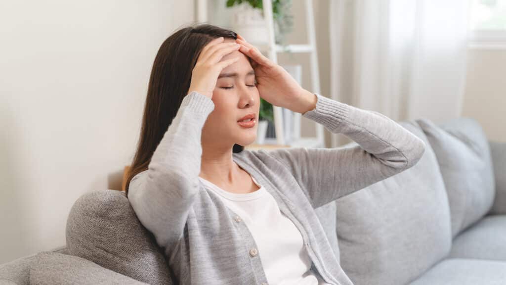 Young Asian females feeling dizzy after standing too fast, have symptoms of low blood pressure