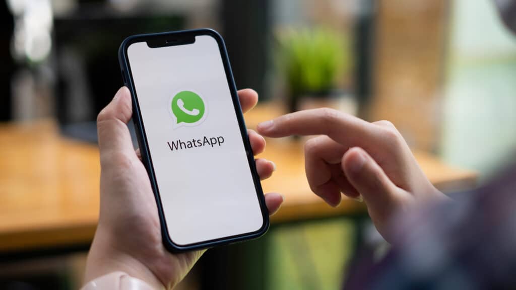 CHIANG MAI, THAILAND - JULY 15 2021 : Man holding a iPhone and open appstore searching social Internet service WhatsApp on the screen. iPhone was created and developed by the Apple inc.