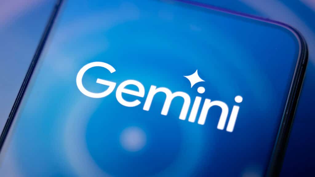 In this photographic illustration, the logo of Gemini artificial intelligence, developed by Google, appears on a smartphone reflecting an abstract illustration dominated by blue colors.