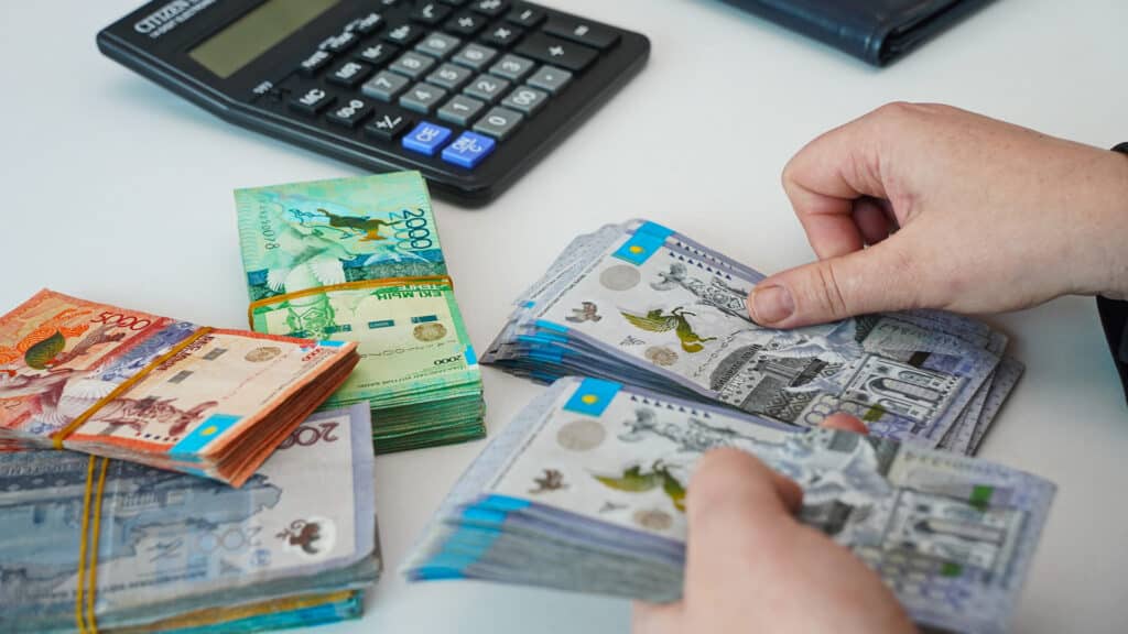 Almaty, Kazakhstan - 01.24.2025 : Banknotes in Kazakhstani tenge are recalculated in the hands.
