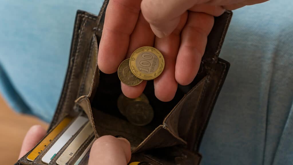 Hand Holding Kazakhstani Tenge Coins in Wallet