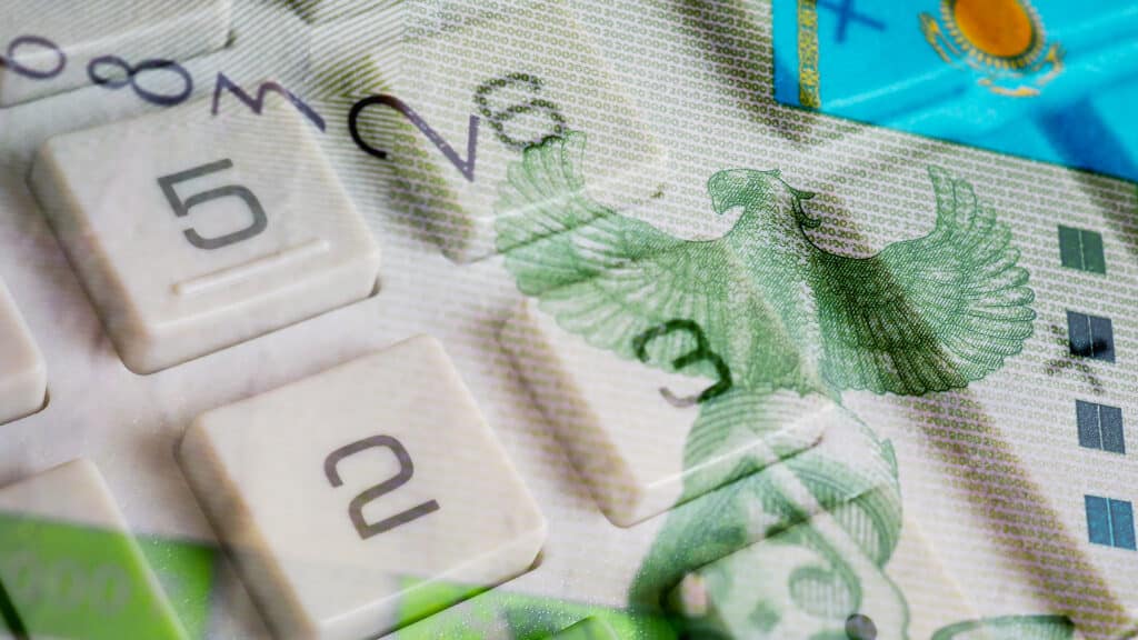 Kazakh paper money. Fragment of 2000 tenge banknote and calculator button close-up. Economic calculation and investment. Credit and interest. Savings in Kazakhstan. Bird Samruk on Kazakh tenge. Macro