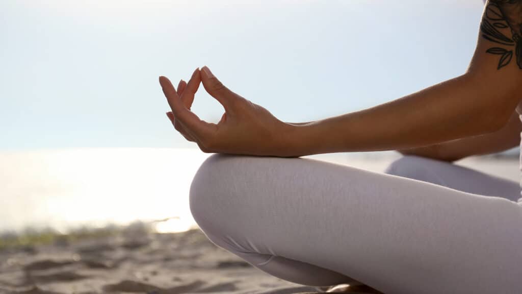 Young woman practicing zen meditation on beach, closeup. Space for text