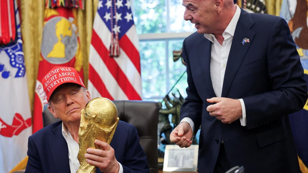 FILE PHOTO: U.S. President Donald Trump holds the FIFA World Cup Trophy, as he makes an announcement on the 2026 FIFA World Cup, as FIFA president Gianni Infantino stands next to him, in the Oval Office at the White House in Washington, D.C., U.S., August 22, 2025. REUTERS/Jonathan Ernst/File Photo